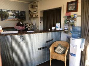 um bar com uma cadeira e uma garrafa de água em Nicholas Royal Motel - No Pets Allowed em Hay