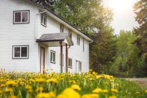a white house with yellow flowers in front of it at Willow Grove B&B Inn in Horsefly