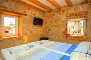 łóżko w pokoju z 2 oknami w obiekcie Villa Veli Varos w Splicie
