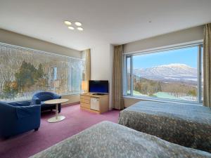雫石町的住宿－雫石王子酒店，酒店客房设有两张床和大窗户。