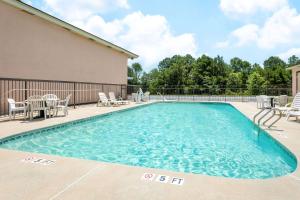 a swimming pool with chairs and a table and chairs at Days Inn by Wyndham Aiken - Interstate Hwy 20 in Aiken