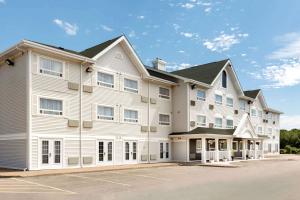 a large white building with a parking lot at Travelodge Suites by Wyndham New Glasgow in New Glasgow