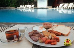 a plate of breakfast food on a table next to a pool at Coral Resort & Bungalows in Haad Rin
