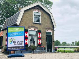 a house with a sign in front of it at De Ouwe Meulen in Bleskensgraaf