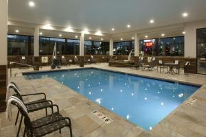 uma grande piscina num hotel com mesas e cadeiras em Quality Inn Oakwood em Spokane