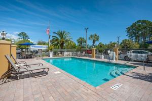 a swimming pool with chairs and an american flag at Comfort Inn Yulee - Fernandina Beach in Yulee