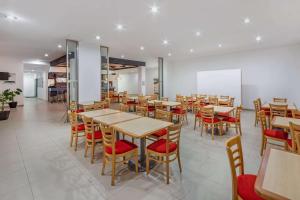 a restaurant with wooden tables and red chairs at Premier Inn Tuxtla in Tuxtla Gutiérrez