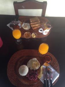 a table with a plate of food and two glasses of orange juice at Napo Beach Resort in Maripipi