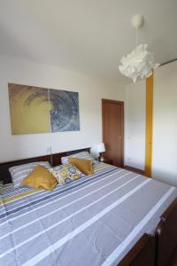 a bedroom with a large bed with yellow pillows at Quater Apartments - Tremezzina in Mezzegra +43 photos
