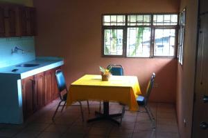 a kitchen with a table with a yellow table cloth at Ecovita Organic Lodge & Farm in Pallatanga