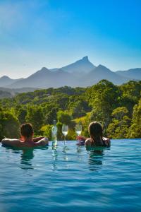 a man and a woman sitting in a swimming pool with wine glasses at La Rochér Eco Retreat in Stokers Siding