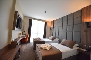 Habitación de hotel con 2 camas y TV en NEW KARAMAN HOTEL en Karaman