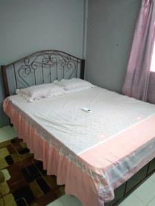 a bed with a white sheets and a pink blanket at Bonda Guesthouse II in Paka