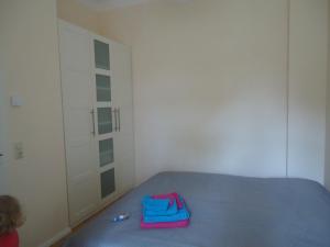 Un dormitorio con una cama azul con una bolsa azul. en Ferienwohnung Gänseblümchen in Buchholz, en Buchholz