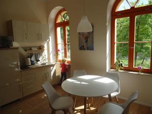 a child standing in a kitchen with a table and chairs at Ferienwohnung Gänseblümchen in Buchholz in Buchholz