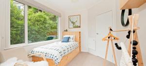 a bedroom with a bed and a large window at Nelson City Escape in Nelson