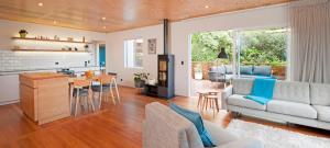 a living room and kitchen with a couch and a table at Nelson City Escape in Nelson