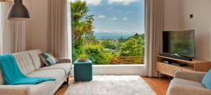 a living room with a couch and a large window at Nelson City Escape in Nelson