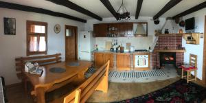 uma cozinha com uma mesa de jantar em madeira e uma lareira em Granny's House em Moisei