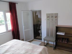 a bedroom with a bed and a bathroom with a shower at Hesta in Vama Veche