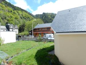 a house with a yard and a house with a mountain at LES EGLETYERES in Le Mont-Dore
