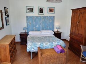 アルゲーロにあるAppartamento Arlinaのベッドルーム1室(青いヘッドボード付きのベッド1台付)