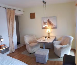 a room with a desk and two chairs and a bed at Ferienwohnung Graf Strandgut in Ostseebad Karlshagen