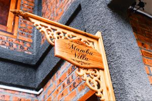 a wooden sign on the side of a building at The Daun Resort Langkawi in Pantai Cenang