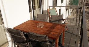 a wooden table and chairs on a balcony at Ankerplatz am Südstrand, Fewo mit 2 Schlafzimmer und eigenen Strandkorb in Binz +19 photos