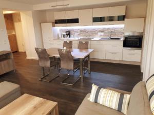 a kitchen and living room with a table and chairs at Ankerplatz am Südstrand, Fewo mit 2 Schlafzimmer und eigenen Strandkorb in Binz
