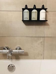 a shelf above a bathroom sink with three bottles on it at Le Cret Haute Nendaz in Nendaz