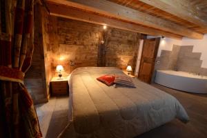 1 dormitorio con cama y bañera en Vieilles Maisons D'Introd, en Introd