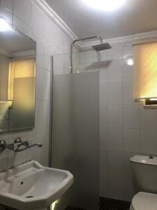 a bathroom with a sink and a glass shower at Masaya Al Deyar Apartments in Amman