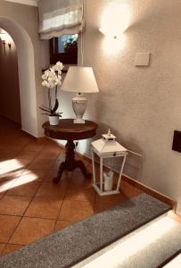 a room with a table with a lamp and a side table at Hotel Adler in Menaggio