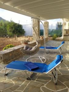 two blue lounge chairs and an umbrella on a patio at BilMar little palace/ steps from the beach in Mármara