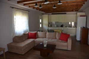 a living room with a brown couch and red pillows at VILA KALIMERA private pool in Nea Potidaea