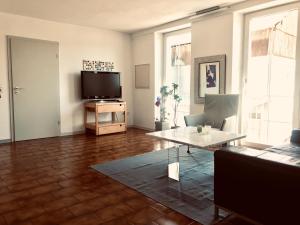 a living room with a television and a table at Talmühle Hirtscheid in Hirtscheid