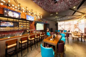 a restaurant with a bar with blue chairs and tables at Citymax Hotel Ras Al Khaimah in Ras al Khaimah