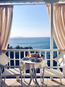 un tavolo e sedie su un balcone con vista sull'oceano di Ikion Eco Boutique Hotel a Patitiri