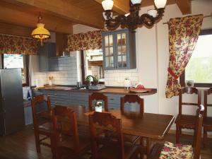 a kitchen with a wooden table and a dining room at Świerkowe Chatki in Olchowiec