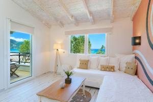 a living room with a bed and a large window at Studios Aigaio in Skala Potamias