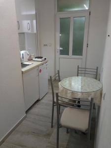 a small kitchen with a glass table and chairs at marko&jana in Ohrid