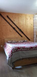 um quarto com uma cama e uma parede de madeira em Le Perce Neige em Vaujany
