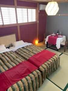 a hotel room with a large bed and a table at オーベルジュ美の浜 流石 in Kasaoka