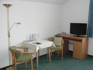 a room with a table and a desk with a computer at Gästehaus Spieker in Horn-Bad Meinberg
