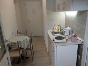 uma pequena cozinha com um lavatório e uma mesa em marko&jana em Ohrid