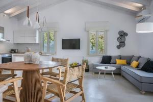 a kitchen and living room with a table and a couch at Olvio Living by the Sea in Sami