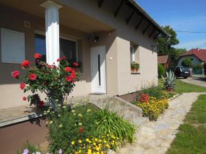 a house with flowers on the side of it at Virágos Apartman Balatonszemes in Balatonszemes