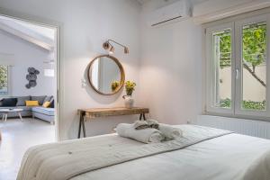 een witte slaapkamer met een bed en een spiegel bij Olvio Living by the Sea in Sami