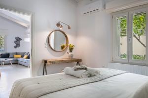 a white bedroom with a bed and a mirror at Olvio Living by the Sea in Sami